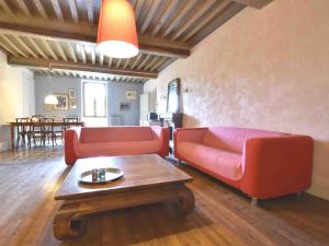 a living room with a red couch and a coffee table at Bright holiday home in Gascony with garden in Gâcogne