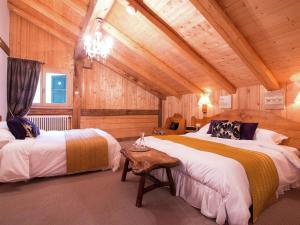 - 2 lits dans une chambre dotée de murs en bois dans l'établissement Charming luxury chalet with sauna, à Morzine