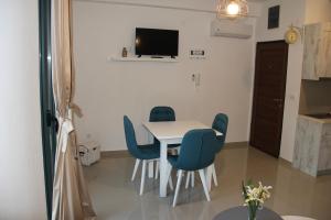 a dining room with a table and blue chairs at Filipa Apartment in Kotor