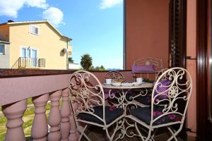 a balcony with two chairs and a table on a balcony at Villa Dalmatino in Pakoštane
