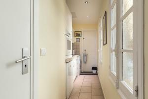 a kitchen with a hallway with a glass door at Very charming studio apartment on port in Cannes a short walk to Palais with Aircon and internet 411 in Cannes