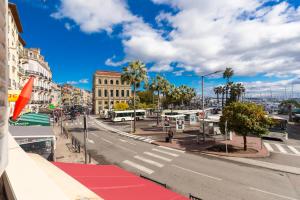 a busy city street with buses and palm trees at Very charming studio apartment on port in Cannes a short walk to Palais with Aircon and internet 411 in Cannes