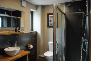 La salle de bains est pourvue de toilettes, d'un lavabo et d'une douche. dans l'établissement The Corran, à Onich