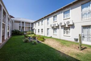 un grande edificio bianco con un cortile con piante di Vetho 2 Apartments OR Tambo Airport a Kempton Park