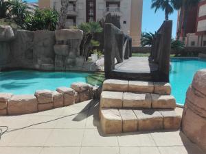 einen Pool mit Wasserfall in einem Resort in der Unterkunft Apartamento Las Gondolas-Tiziano in La Manga del Mar Menor