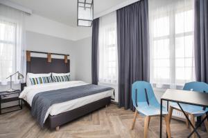 um quarto com uma cama, uma mesa e cadeiras em Pensjonat Victoria by OneApartments em Sopot