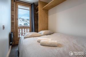 蒂涅的住宿－Tignes 301，一间卧室配有一张带两个枕头的床