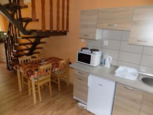 cocina con mesa y microondas en la barra en Nárcisz apartman en Gyula