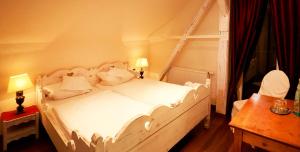 ein Schlafzimmer mit einem weißen Bett und einem Fenster in der Unterkunft Hotel Der Grischäfer in Bad Emstal