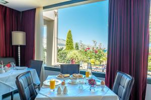a dining room with two tables and a large window at Ai Yannis Suites and Apartments Hotel in Mármaron