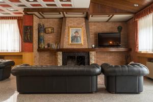 a living room with two leather couches and a fireplace at Hotel Tasso in Camigliatello Silano