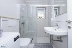 a white bathroom with a shower and a sink at Apartment Antonella in Dubrovnik