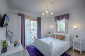 a bedroom with a white bed and a window at Gobene Alacati in Alaçatı