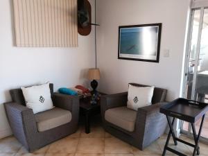 a living room with two chairs and a table at 404 Ipanema Beach in Durban
