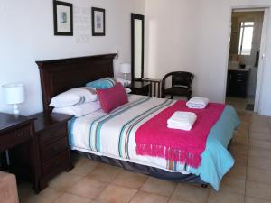 a bedroom with a large bed with a red blanket at 404 Ipanema Beach in Durban