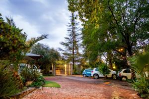 a parking lot with cars parked in a driveway at @The Villa Guest House in Bloemfontein