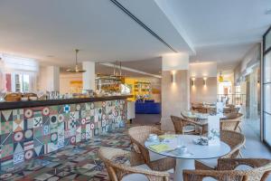 a restaurant with tables and chairs and a counter at Hotel Cala Sant Vicenç - Adults Only in Cala de Sant Vicenc
