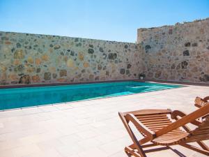 a swimming pool with a chair and a table and a chair at La Fuente del Pinar in Valdesimonte