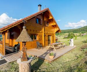 een blokhut met een houten terras ervoor bij LE QUARTZ DES HAUTES-VOSGES in Xonrupt-Longemer