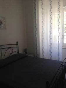 um quarto com uma cama e uma janela em Apartment Cara Sibilla em Marsala