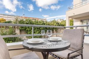 a table and chairs on a balcony with wine glasses at Royal Regency Paris Vincennes in Vincennes