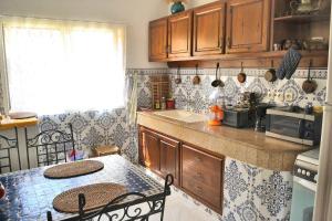 una cocina con armarios de madera y una mesa con sillas. en Appartement 400m plage 4eme étage en El Jadida