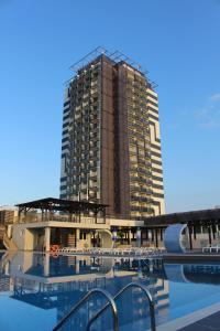 a tall building with a pool in front of a building at Burgas Beach Hotel in Sunny Beach