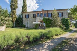 an old stone house with a path leading to it at Podere Sant'Alessandro in Rapolano Terme