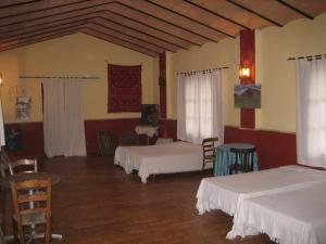 Habitación con 3 camas, mesa y sillas en Molino Jabonero, en Villanueva del Trabuco
