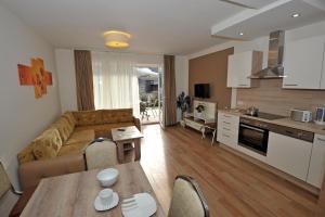 a kitchen and living room with a couch and a table at Sunshine Apartments - Great Mountain View in Schladming