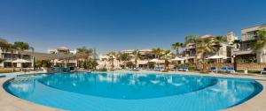 a large swimming pool at a resort with palm trees at JAZ Little Venice Golf Resort in Ain Sokhna