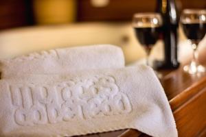 a towel on a table with two glasses of wine at Hotel Moradas do Penedo in Penedo