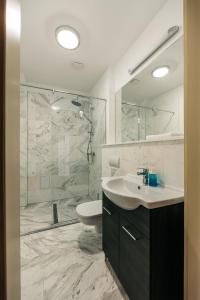 Un baño con inodoro, lavabo y ducha. en YellowBoot Aparthotel, en Sibiu
