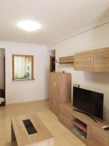 a living room with a flat screen tv and wooden cabinets at Apartamento Costa Marina III Magic World in Oropesa del Mar