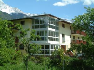 a large white building with mountains in the background at Hotel Stefanshof in Plaus