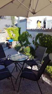 a patio with a table and chairs under an umbrella at House Čeh in Črni Kal