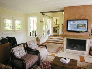 a living room with a fireplace and a tv at Pousada Mar Deny Campos in Campos do Jordão