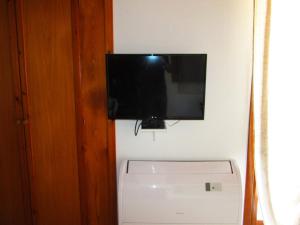 カステルサルドにあるAppartamento Sul Mareの冷蔵庫の上に壁掛けの薄型テレビが備わります。
