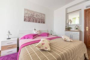 a bedroom with a large bed with pink pillows at Apartment Dujić with hot tub in Kaštela +55 photos