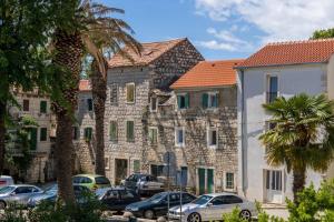 a group of buildings with cars parked in a parking lot at Apartment Dujić with hot tub in Kaštela