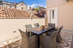 a wooden table and chairs on a balcony at Apartment Dujić with hot tub in Kaštela