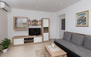 sala de estar con sofá y TV en NORA APARTMENT by DuHomes, en Dubrovnik