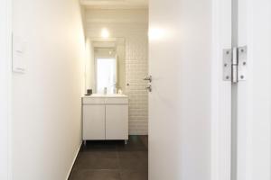 a white bathroom with a sink and a mirror at Msc Flats in Porto +19 photos