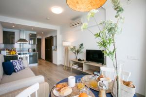 a living room with a table with food on it at Pierre & Vacances Blanes Playa in Blanes