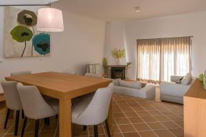 a living room with a wooden table and chairs at T3 Vila dos Principes in Amoreira