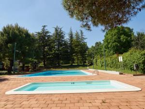 an empty swimming pool in a park with trees at Appartamento Anna in Desenzano del Garda
