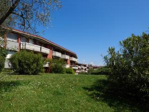 ein Gebäude mit einem Grasfeld davor in der Unterkunft Appartamento Anna in Desenzano del Garda