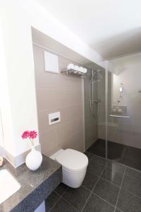 a bathroom with a toilet and a glass shower at MAVO Hospitality by Büroma Apart Apartmentvermietung GmbH Esslingen in Esslingen