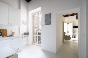 a kitchen with white walls and a table and a chair at White Ostilia Apartments in Rome +195 photos