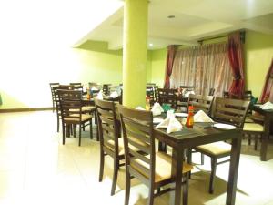 a dining room with wooden tables and chairs at Savannah Paradise Hotel in Makindu